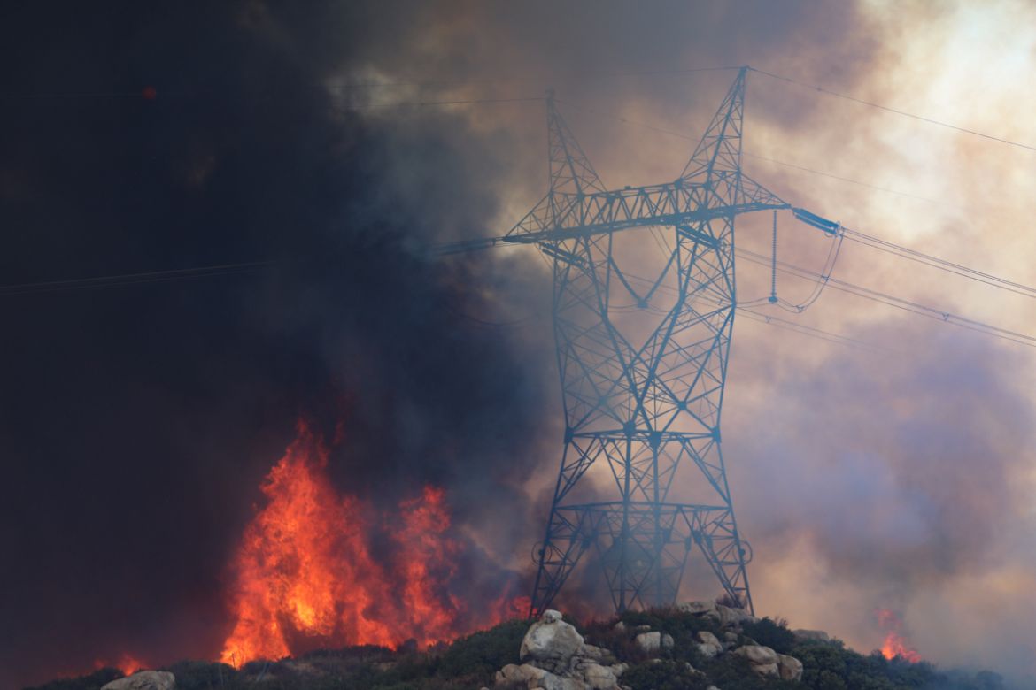 Power lines lie in the path of an approaching brush fire along Japatul Road during the Valley Fire in Jamul, California on September 6, 2020 - The Valley Fire in the Japatul Valley burned 4,000 acres