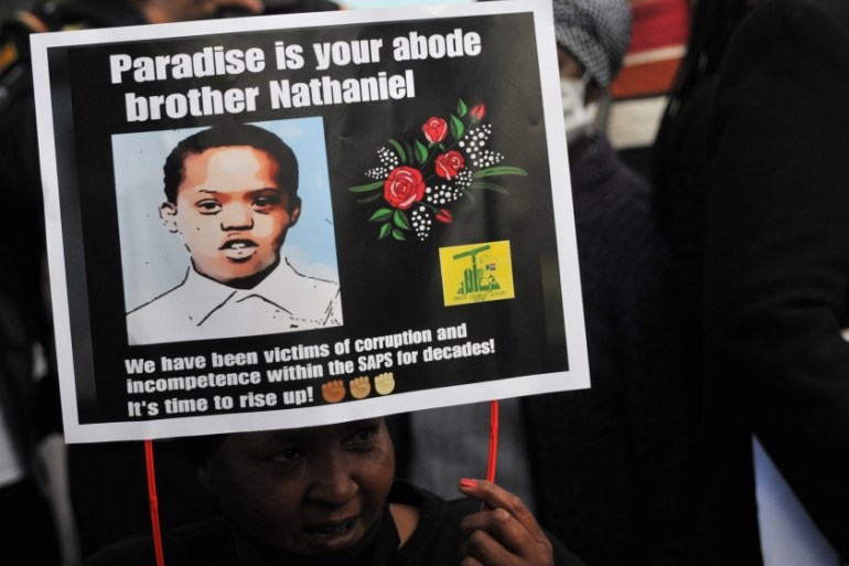 Community members demonstrate during a sit down peaceful protest against the killing of 16 year old Nathaniel Julius at Eldorado Park Police Station on August 30, 2020 in Eldorado Park, South Africa.