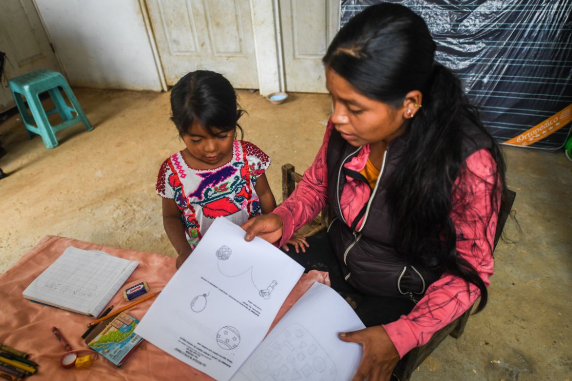 Natalia Vazquez (R) helps her daughter to take a lesson at their home in San Miguel Amoltepec Viejo, Guerrero state, Mexico, on September 8, 2020, amid the COVID-19 coronavirus pandemic. - Teachers re