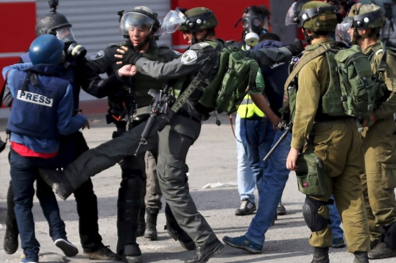 An Israeli border policeman kicks a Palestinian photojournalist during clashes with Palestinian protesters near the Jewish settlement of Bet El, near the West Bank city of Ramallah October 30, 2015. K