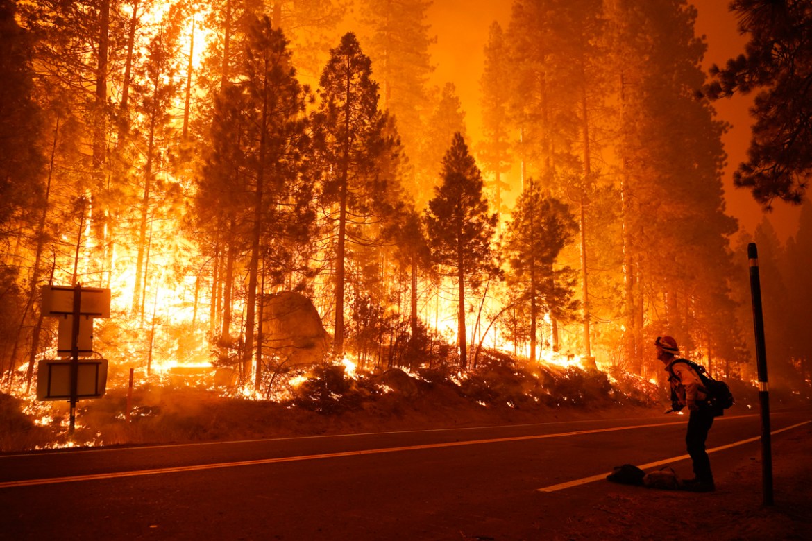 Gabe Huck, right, a member of a San Benito Monterey Cal Fire crew, stands along state Highway 168 while fighting the Creek Fire, Sunday, Sept. 6, 2020, in Shaver Lake, Calif. (AP Photo/Marcio Jose San