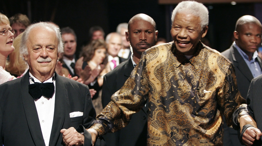 George Bizos, left, anti-apartheid activist, and life-long friend and lawyer of Nelson Mandela, right, arrives for his 80th birthday party in Johannesburg, South Africa. Bizos has died Wednesday Sept.