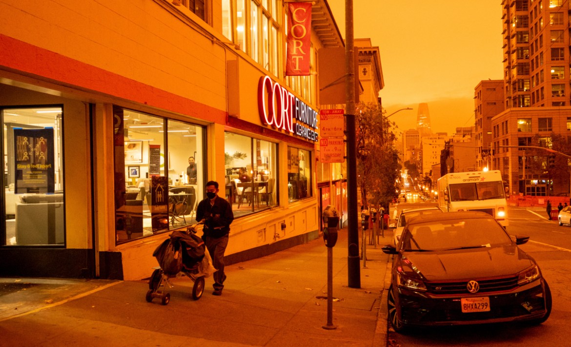 A man walks by CORT Furniture Outlet on Sutter St as an orange wildfire haze blankets San Francisco, California, U.S., September 9, 2020 in this image obtained from social media. Courtesy of Adrianna