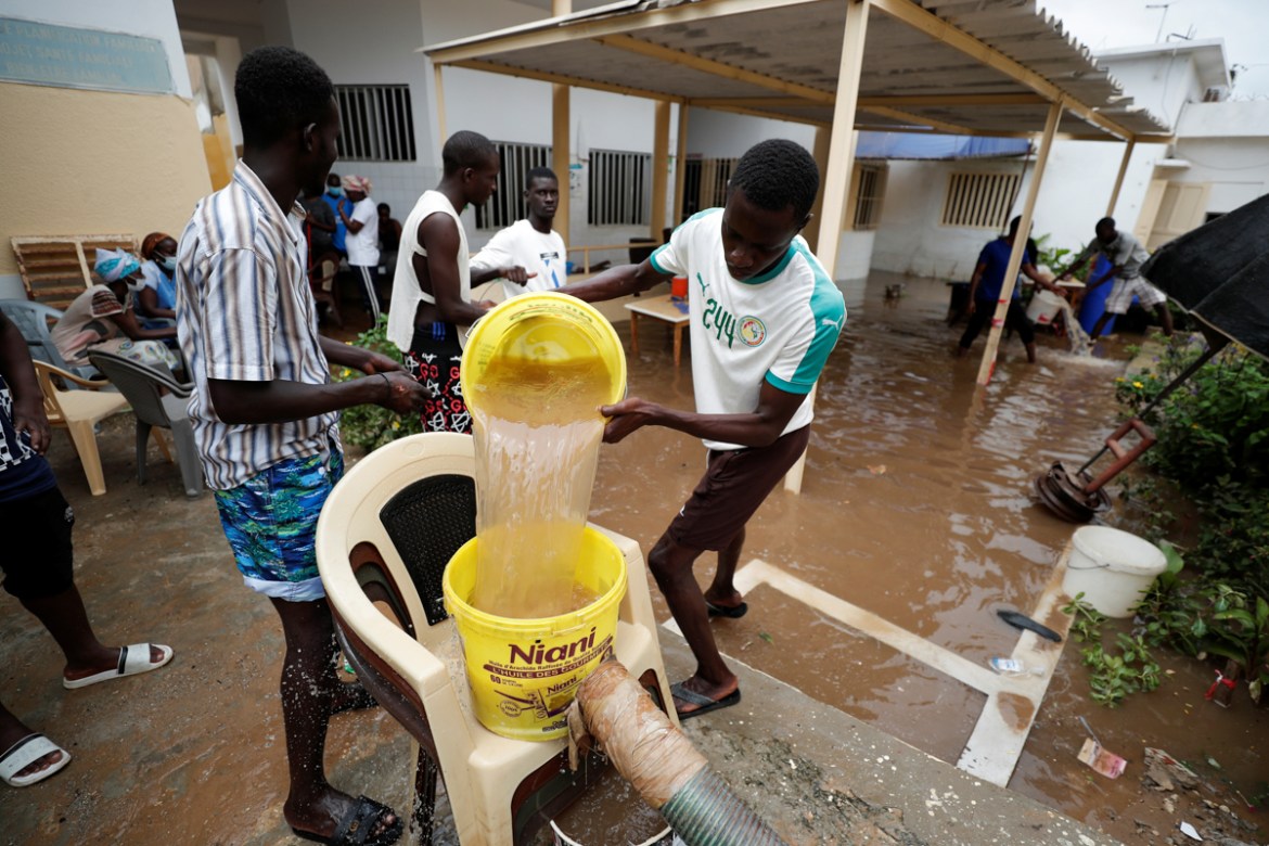 A volunteer removes water from a flooded Health center after heavy rains in Guediawaye on the outskirts of Dakar, Senegal September 6, 2020.REUTERS/ Zohra Bensemra