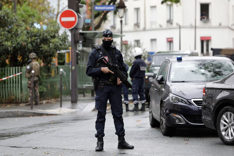 A French riot police officer stands guard after a knife attack near the former offices of satirical newspaper Charlie Hebdo