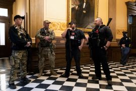 Members of a militia stand in the Capitol Hill building in Lansing, Michigan on April 30, 2020 [Seth Herald/Reuters]