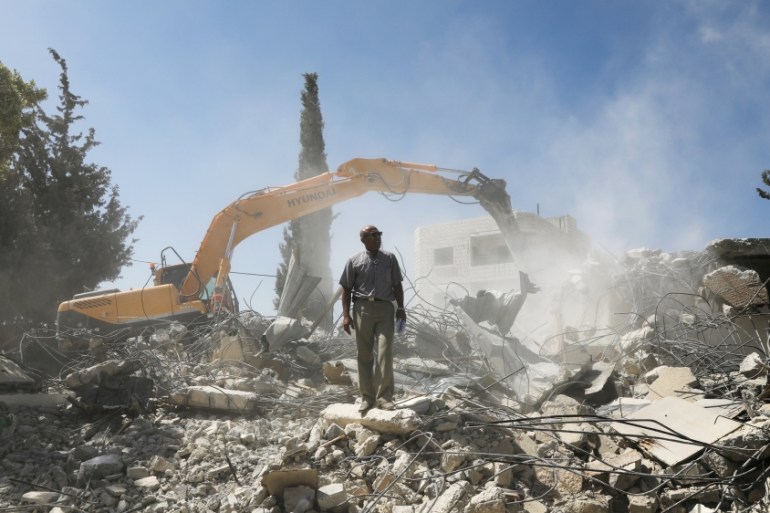 Palestinian Jihad Shawamrah stands on ruins of his house that he demolished in East Jerusalem
