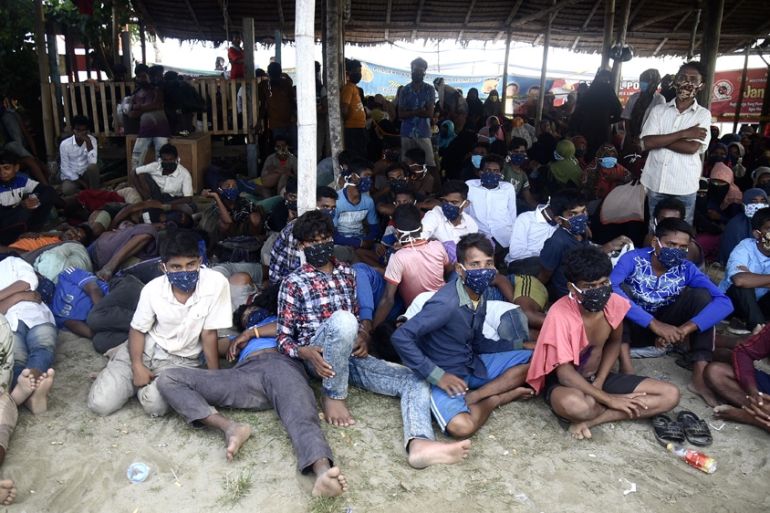Rohingya refugees sitting beneath a shelter after arriving in Aceh in Sept 2020. They look tired and thin. They are barefoot