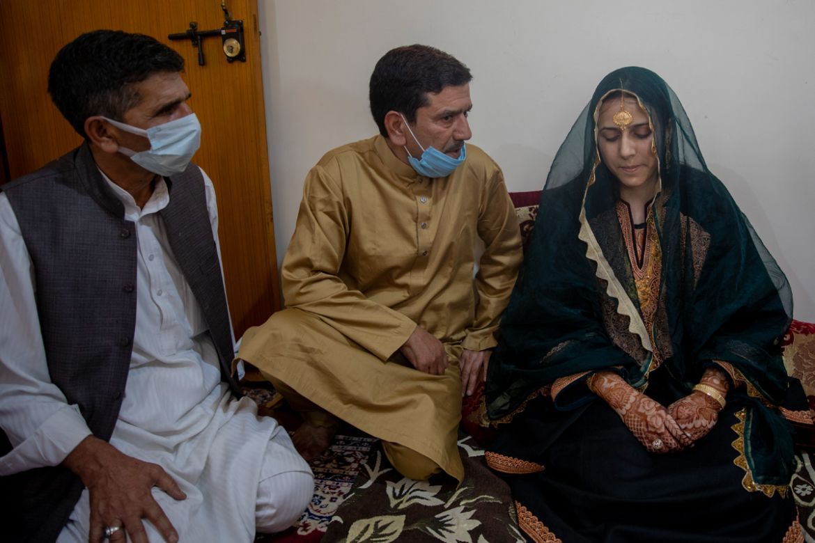 Fayaz Ahmed, center and Manor Ahmed, left, uncles of Kashmiri bride Saima Ashraf, ask her permission before Nikah ceremony during a wedding on the outskirts of Srinagar, Indian controlled Kashmir, Thu