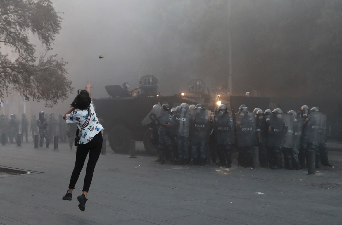 An anti-government protester throws a stone towards riot police during a protest near Parliament Square, In Beirut, Lebanon, Tuesday, Sept. 1, 2020. On a visit to Lebanon, French President Emmanuel Ma