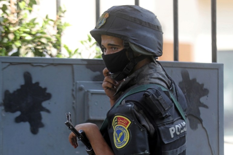 Police officer wearing protective mask stands guard in Cairo