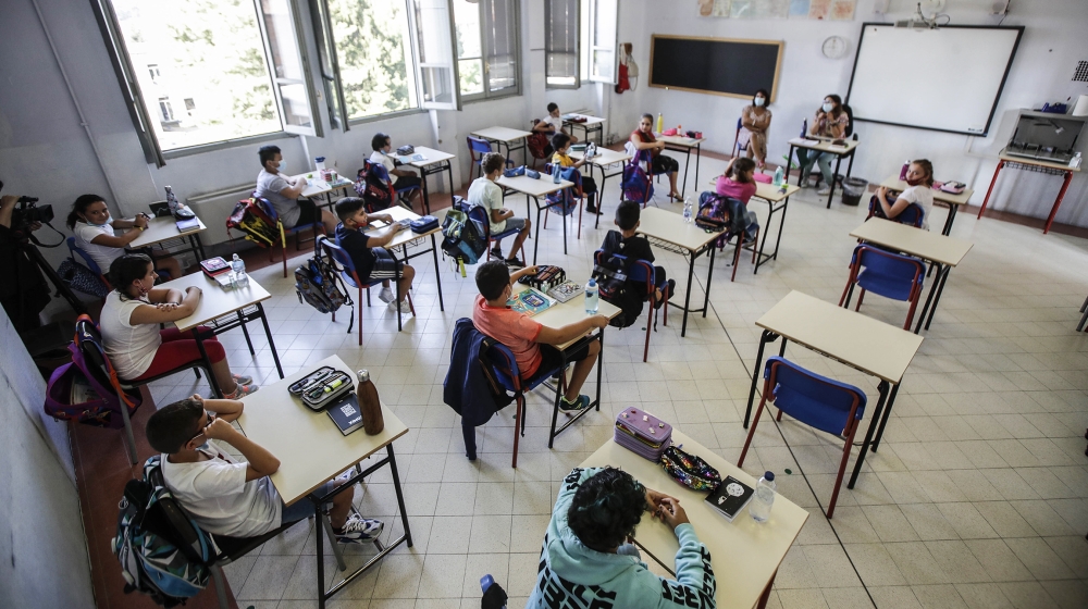 Students sit in their classroom at the San Biagio primary school in Codogno, Italy, Monday, Sept. 14, 2020. The morning bell Monday marks the first entrance to the classroom for the children of Codogn