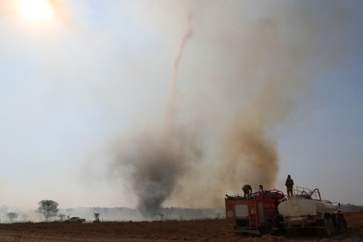 Firefighters from the State of Mato Grosso fill their truck with water as they prepare to extinguish a fire in front of a smoke funnel, on a farm in the Pantanal, the world''s largest wetland, in Pocon