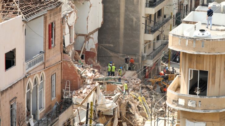 Volunteers and a Chilean rescue team member dig through the rubble of buildings which collapsed due to the explosion at the port area, after signs of life were detected, in Gemmayze, Beirut