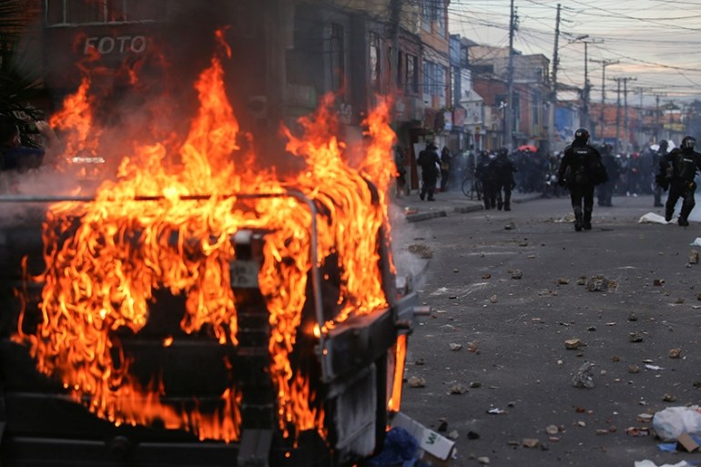 A garbage container burns during protests after a man, who was detained for violating social distancing rules, died from being repeatedly shocked with a stun gun by officers, according to authorities,