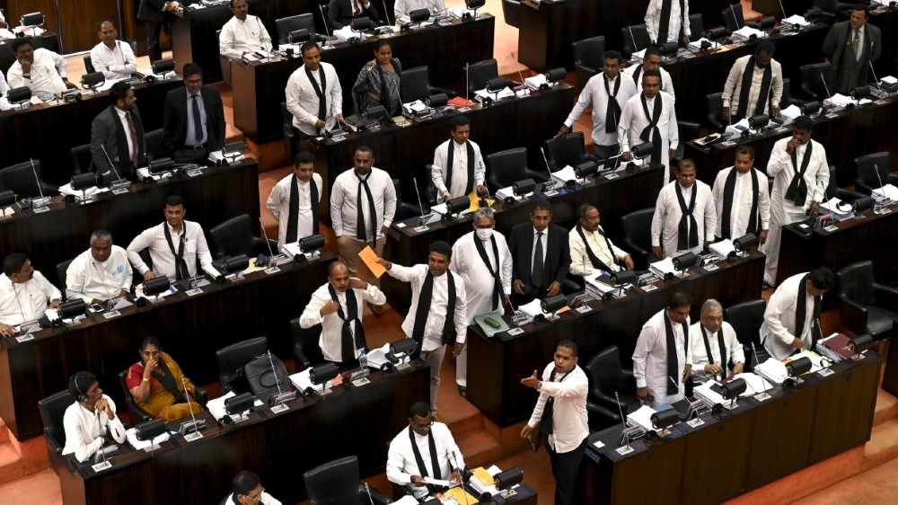 Sri Lanka's opposition legislators wearing black shawls protest in parliament as Sri Lanka's convicted murderer Premalal Jayasekara (unseen) takes oaths as a member of parliament from