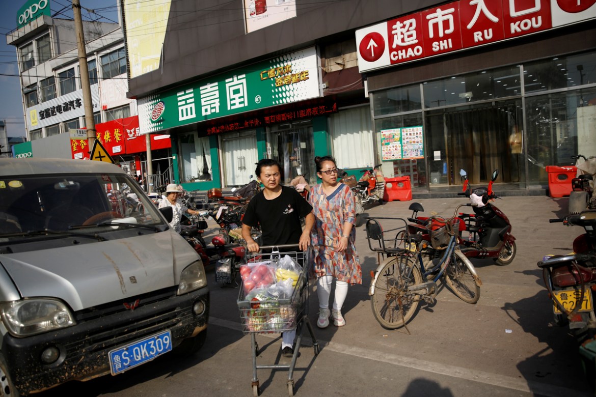 Priest Deng Shiquan, 28, a former restaurant worker, pushes a shopping cart next to priest Cao Shijing, 45, outside a supermarket after buying groceries to take to the Jiuyang Palace, a Taoist monaste