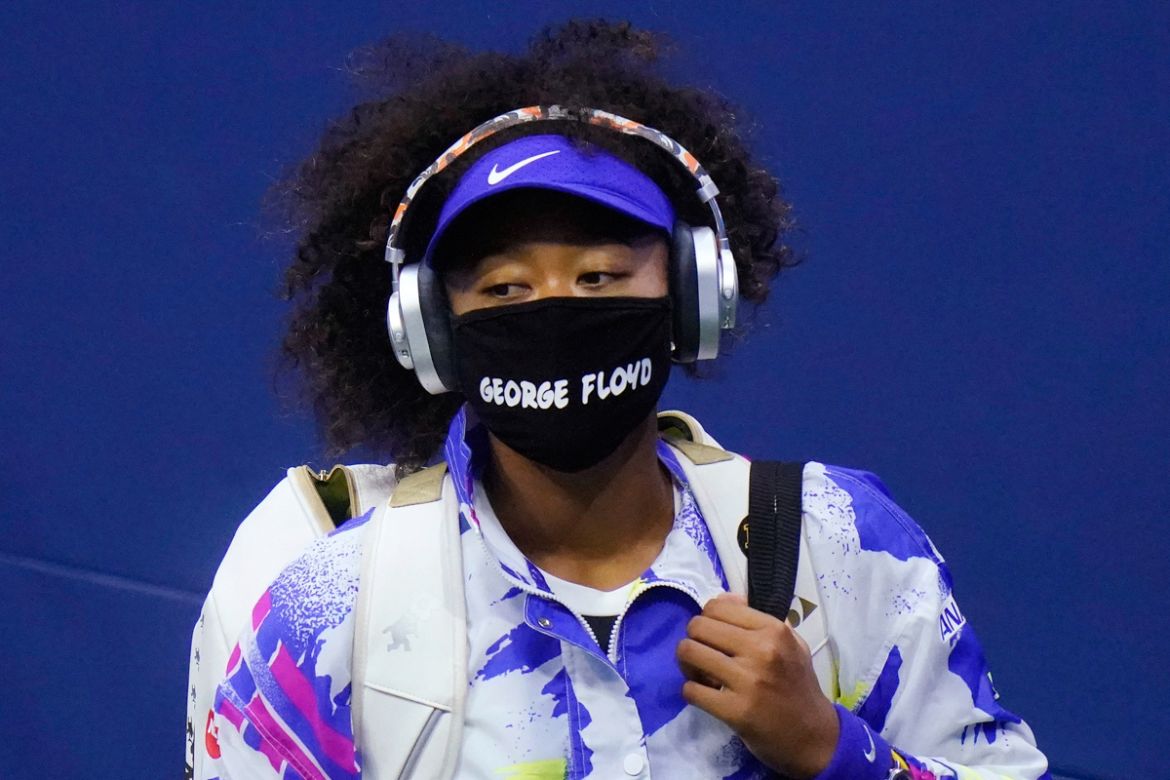 Naomi Osaka, of Japan, wears a protective mask due to the COVID-19 virus outbreak, featuring the name "George Floyd", while arriving on court to face Shelby Rogers, of the United States, during the qu