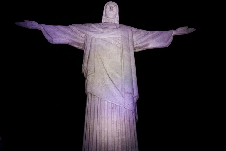 Members of the Red Cross stand at the Christ the Redeemer statue during a tribute to their assistance to Brazilians during the coronavirus disease (COVID-19) outbreak, in Rio de Janeiro, Brazil, Augus