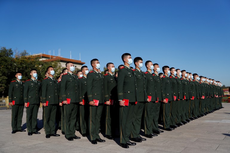 Soldiers stand in formation in front of the Great Hall of the People ahead of an event to mark the 70th anniversary of China entering the Korean War at the Great Hall of the People in Beijing [Carlos Garcia Rawlins/Reuters]