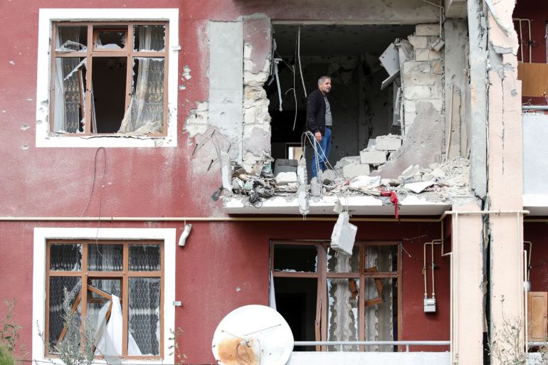 A man looks out from his damaged home after a ceasefire begins during the fighting over the breakaway region of Nagorno-Karabakh in the city of Terter