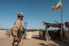 A member of the Amhara Special Forces watches on at the border crossing with Eritrea while where an Imperial Ethiopian flag waves, in Humera, Ethiopia, on November 22, 2020. [Eduardo Soteras/AFP]