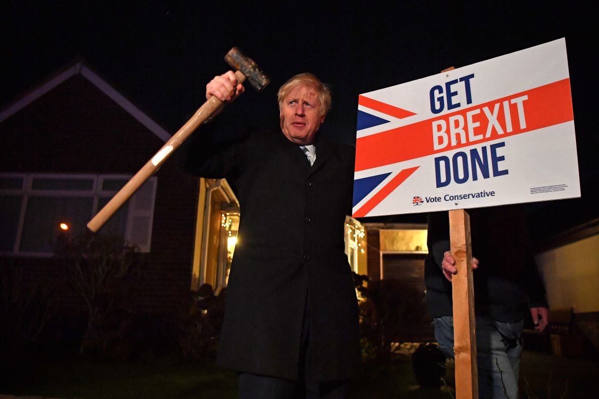 Boris poses after hammering a "Get Brexit Done" sign into the garden