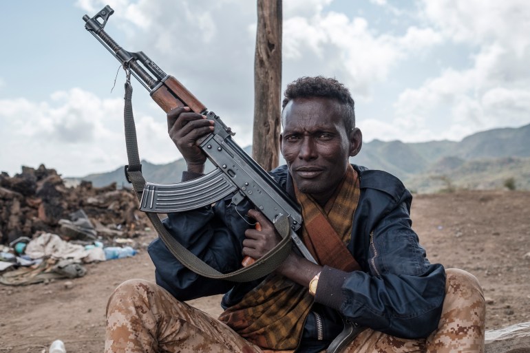 A member of the Ethiopian government's Afar Special Forces unit poses with his weapon in the outskirts of the village of Bisober in Ethiopia's Tigray region [Eduardo Soteras/AFP]