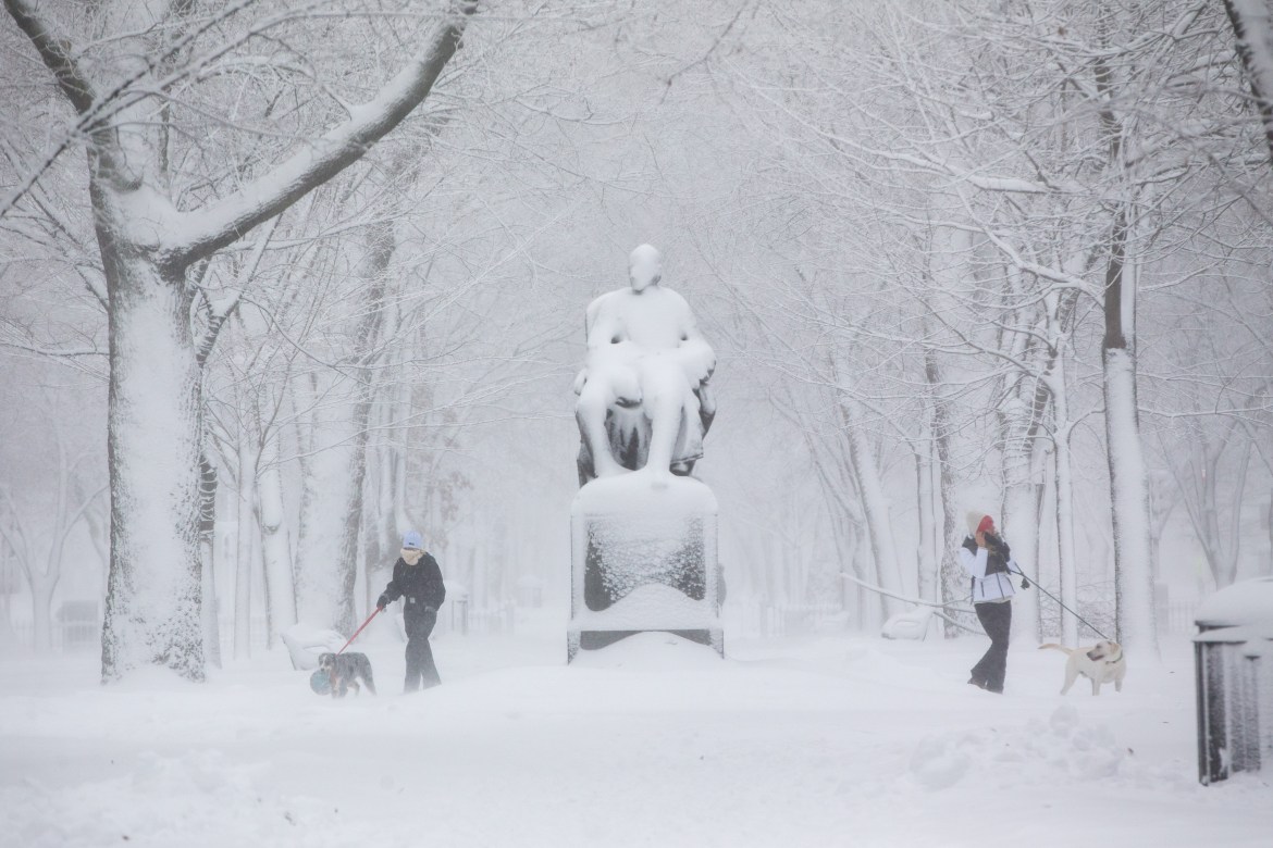 People walk their dogs on the snow-blanketed Commonwealth Mall in Boston, Massachusetts. More than a foot of snow is expected in the Greater Boston area as the winter storm delivers snow, rain, sleet and high winds up and down the East Coast. [Scott Eisen/Getty Images/AFP]