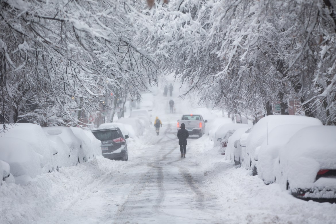 People walk down a snow-covered Chestnut Street in Boston, Massachusetts. More than a foot of snow was expected [Scott Eisen/Getty Images/AFP]