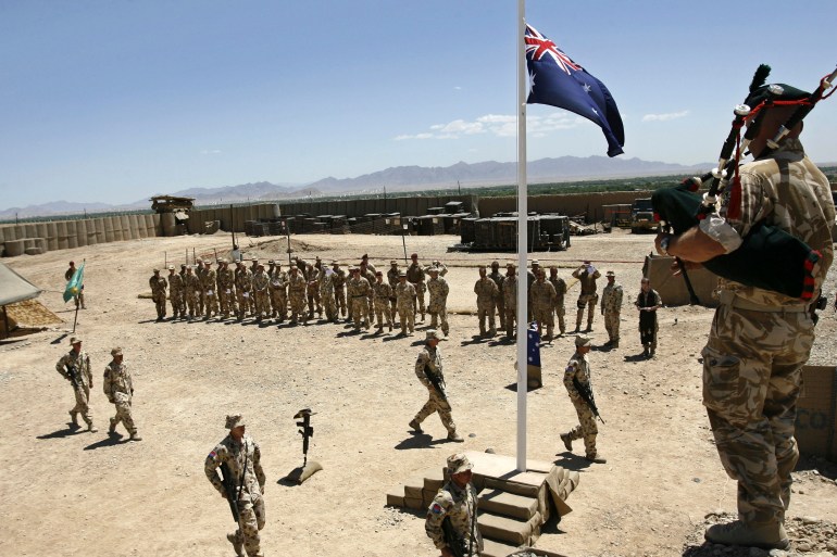 Australian and British troops stand at attention during an ANZAC day ceremony at Camp Armadillo in Afghanistan on April 25, 2008 [Reuters/Omar Sobhani]