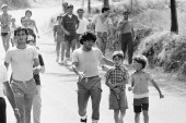 Argentine football icon Diego Armando Maradona talks to a young fan while sightseeing after training with his new team, Napoli in Castel Del Piano, Italy on July 27, 1984 [File: Massimo Sambucetti/AP Photo]