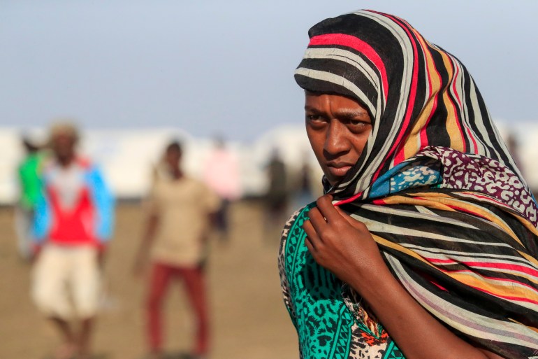 An Ethiopian refugee from Tigray walks in the Tenedba camp in Mafaza, eastern Sudan [Ashraf Shazly/AFP]