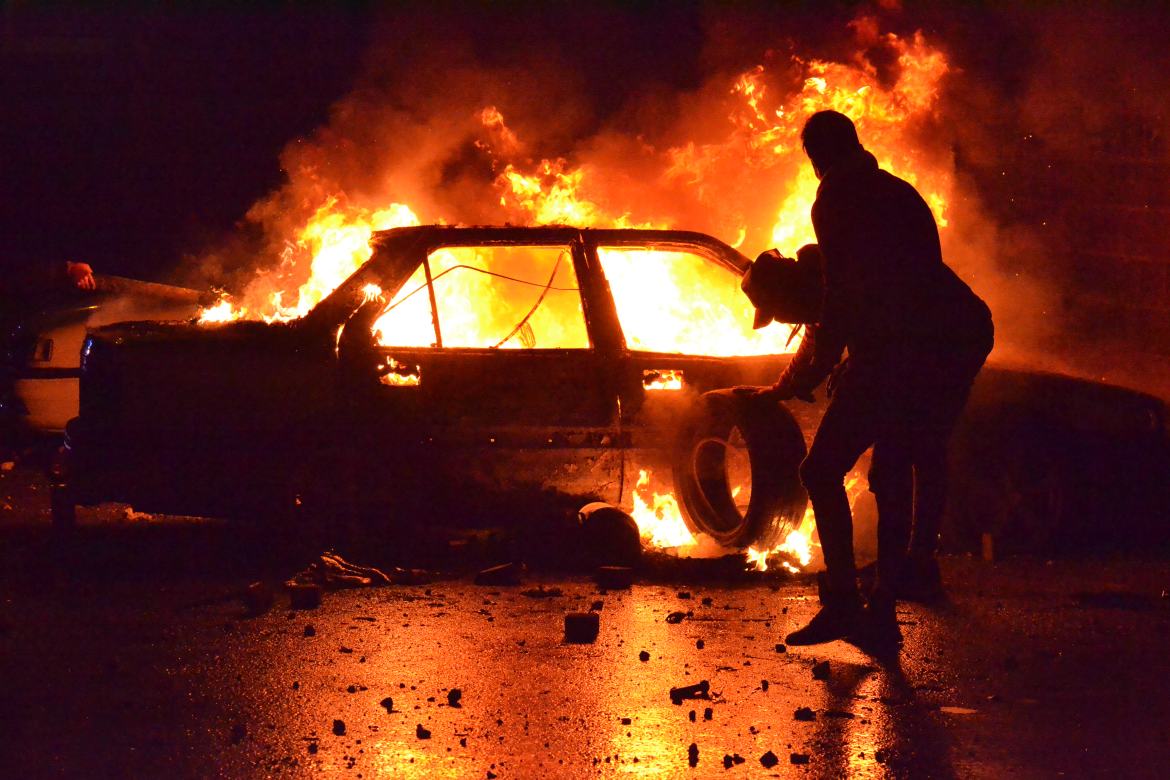 Lebanese protesters burn a vehicle in the northern port city of Tripoli. [Fathi al-Masri/AFP]