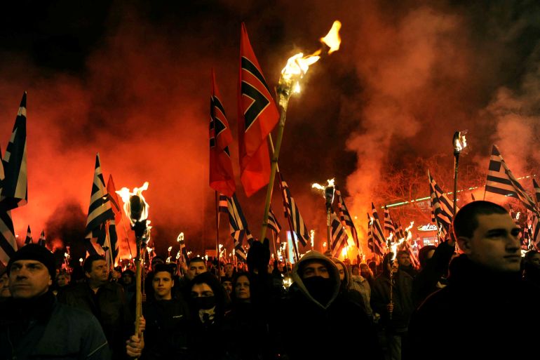 Supporters of Greece's far-right Golden Dawn party lift torches at a protest