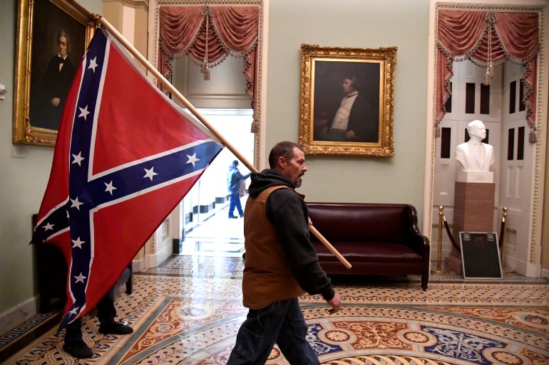 Man holding Confederate flag during US Captiol riot arrested | Donald Trump  News | Al Jazeera