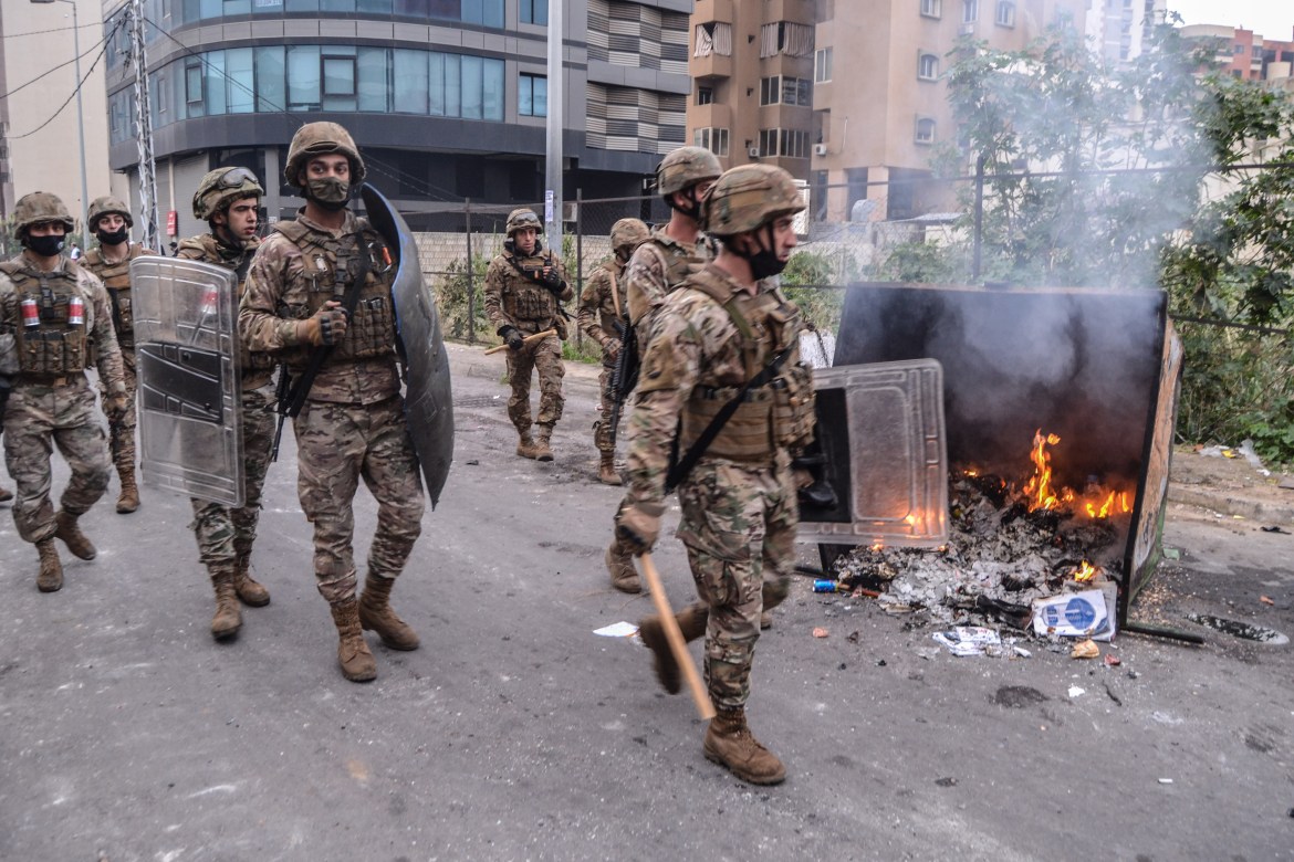 Lebanese soldiers walk in Tripoli during an anti-lockdown protest. [EPA]