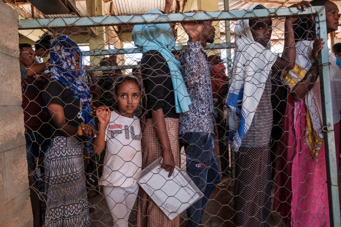 Eritrean refugees queue during a UNHCR distribution campaign at Mai Aini refugee camp. [Eduardo Soteras/AFP]