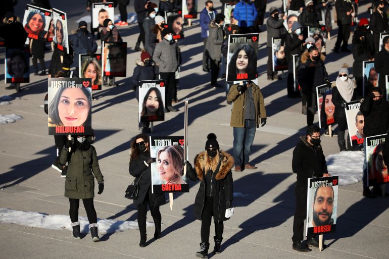 People hold placards with images of the victims of the downing of Ukraine International Airlines flight PS752, in Toronto last year