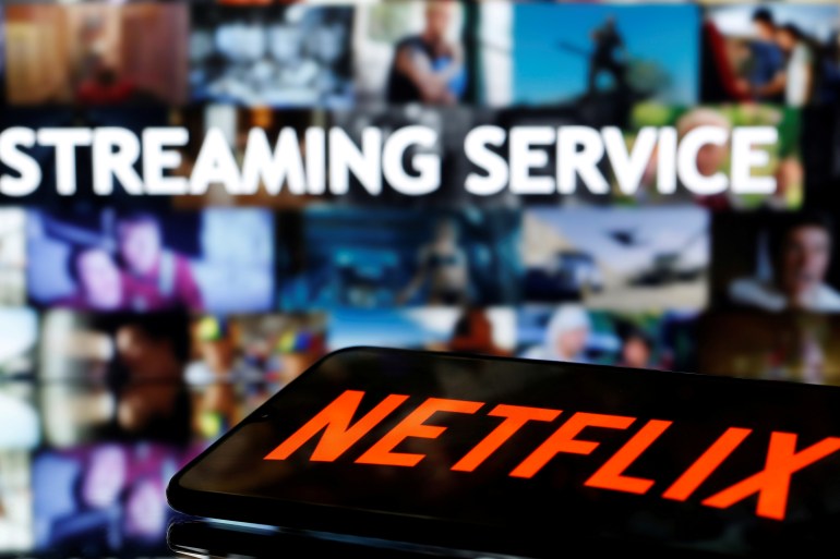 A smartphone with the Netflix logo lies in front of displayed "Streaming service" words in this illustration taken March 24, 2020. REUTERS/Dado Ruvic/Illustration/File Photo GLOBAL BUSINESS WEEK AHEAD