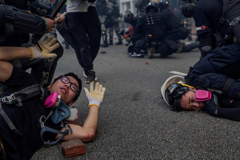 Anti-government protesters are detained during skirmishes with police in Hong Kong [File: Susana Vera/Reuters]