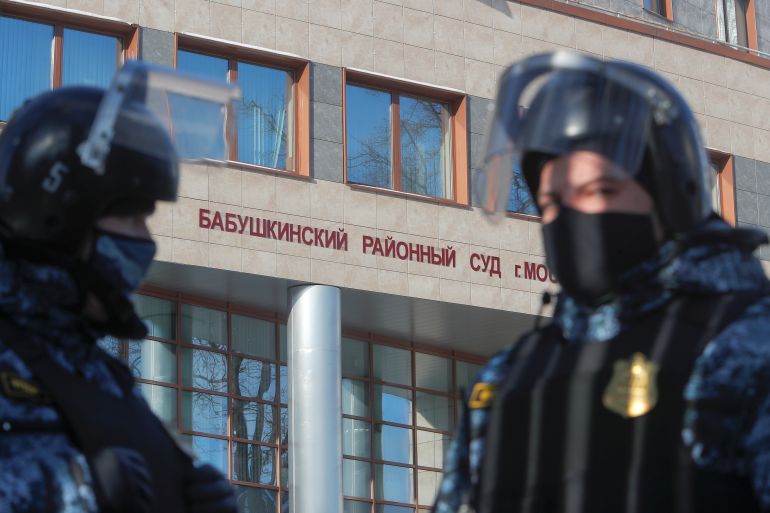 Russian law enforcement officers stand guard outside a court building in Moscow during a hearing to consider the case against Kremlin critic Alexey Navalny