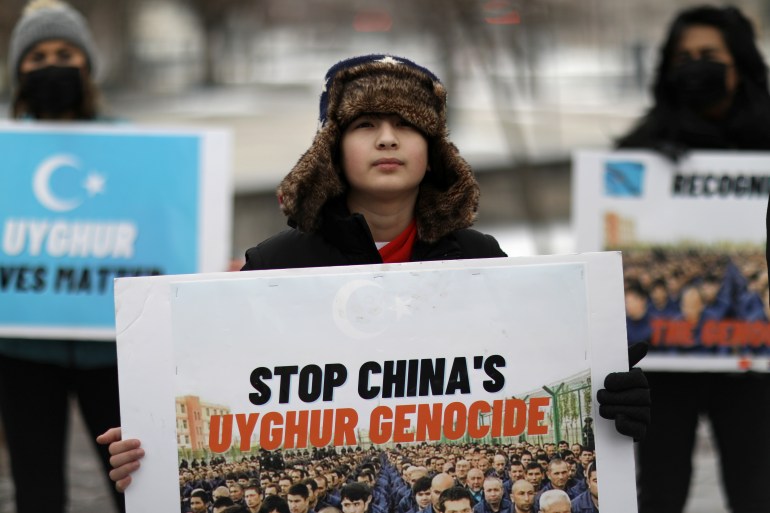 Um manifestante segurando uma placa que diz: "Acabar com o genocídio uigur na China".