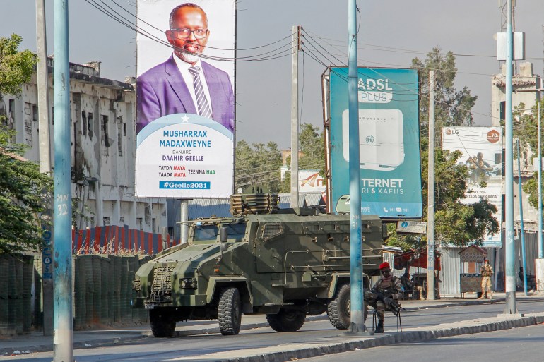 Security forces block a street with an armoured personnel carrier during protests against the government and the delay of the country's election in the capital Mogadishu, Somalia, Feb 19, 2021. [AP Photo]