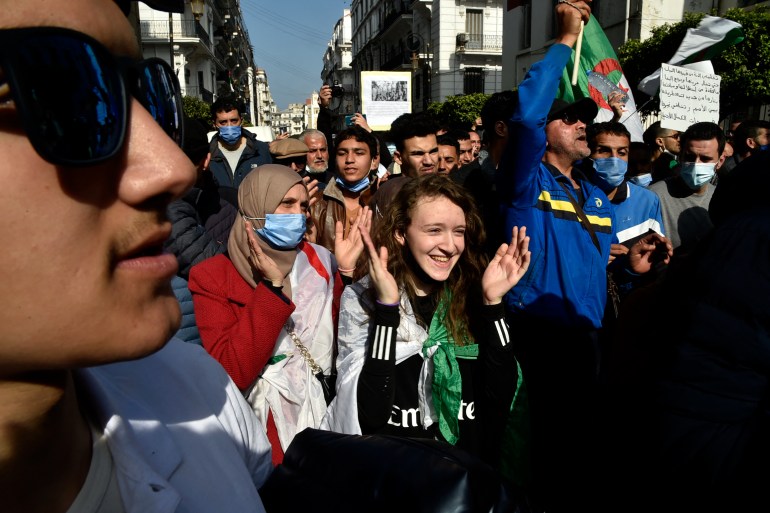 Algerian demonstrators march during an anti-government protest in the capital Algiers on Friday [Ryad Kramdi/AFP]