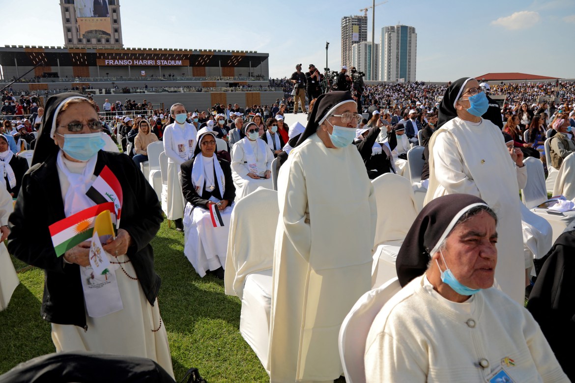 Para biarawati menunggu kedatangan Paus Fransiskus di Stadion Franso Hariri di Erbil.  Misa yang diadakan dalam bahasa Italia terdiri dari himne yang diadakan dalam bahasa Arab dan Siria, bahasa penduduk Kristen setempat, dimainkan oleh orkestra yang terdiri dari sekitar 80 musisi.  [Safin Hamed / AFP]