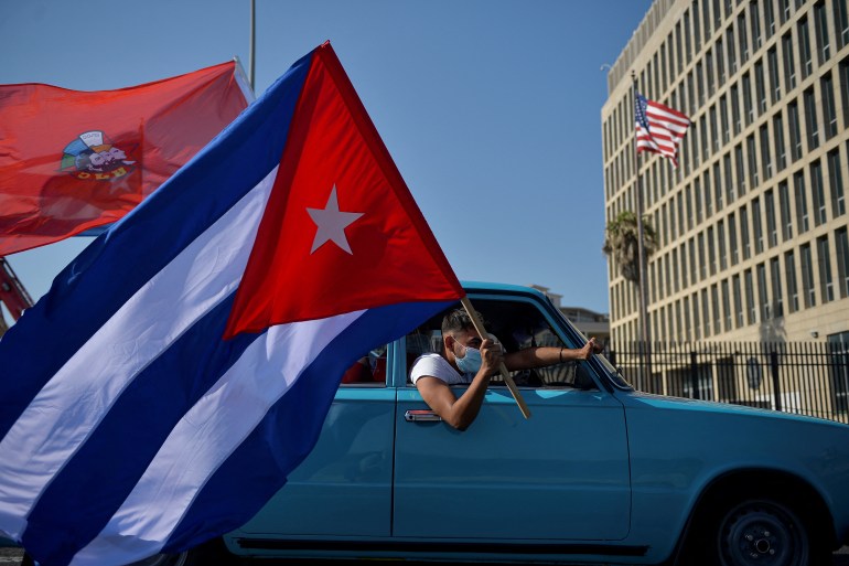 Cubans drive past the US embassy during a rally calling for the end of the US blockade against Cuba, in Havana, March 28, 2021 [Yamil Lage/AFP]