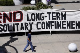 A protestor holds a banner calling for an end to solitary confinement