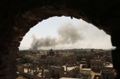 Smoke and dust rise near buildings from air strikes launched by the Saudi-led coalition on Sanaa, Yemen on March 7, 2021 [Khaled Abdullah/Reuters]