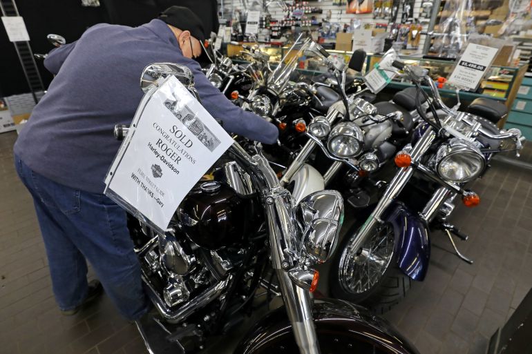 Gary Haines of Cycle World Superstore places a SOLD sign on a Harley Davidson motorcycle that had been purchased by a customer in Toronto, Ontario, Canada